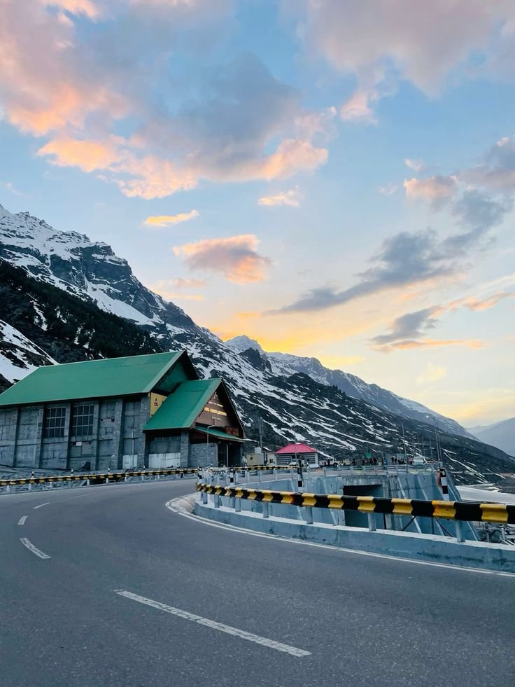 Atal Road Tunnel portal at sunset, with the Himalayan range behind